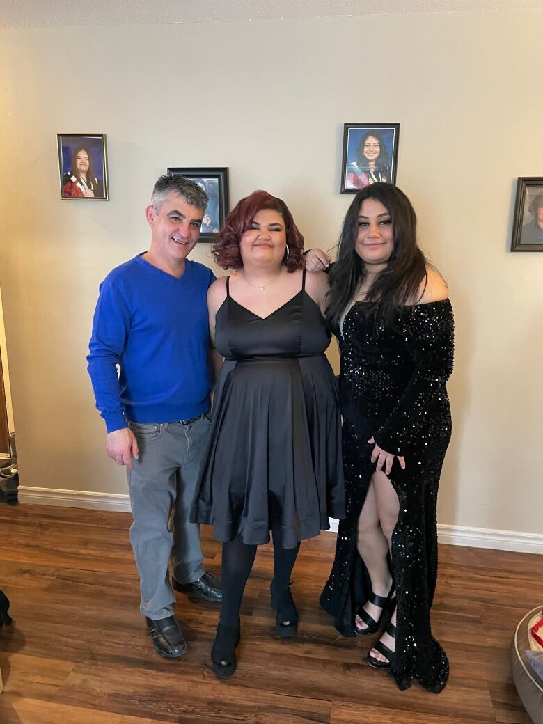 Three people in formal clothes smiling at the camera.