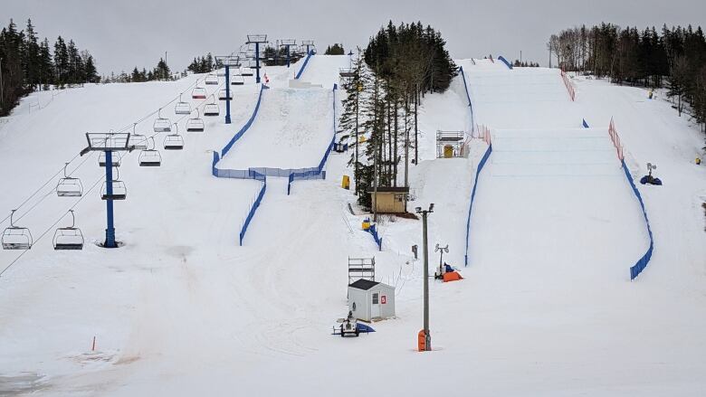 A snowy slope. A ski lift can be seen on the left.