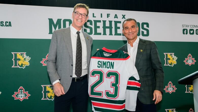 Bobby Smith, left, presents new Halifax Mooseheads owner Sam Simon with a new team jersey. 