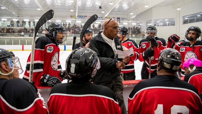 Honourary head coach John Paris Jr., centre, speaks with an all-Black roster representing the Dartmouth Jubilees at a game commemorating the history of the Coloured Hockey League of the Maritimes at the RBC Centre, in Dartmouth, N.S., in a Saturday, Feb. 18, 2023, handout photo.