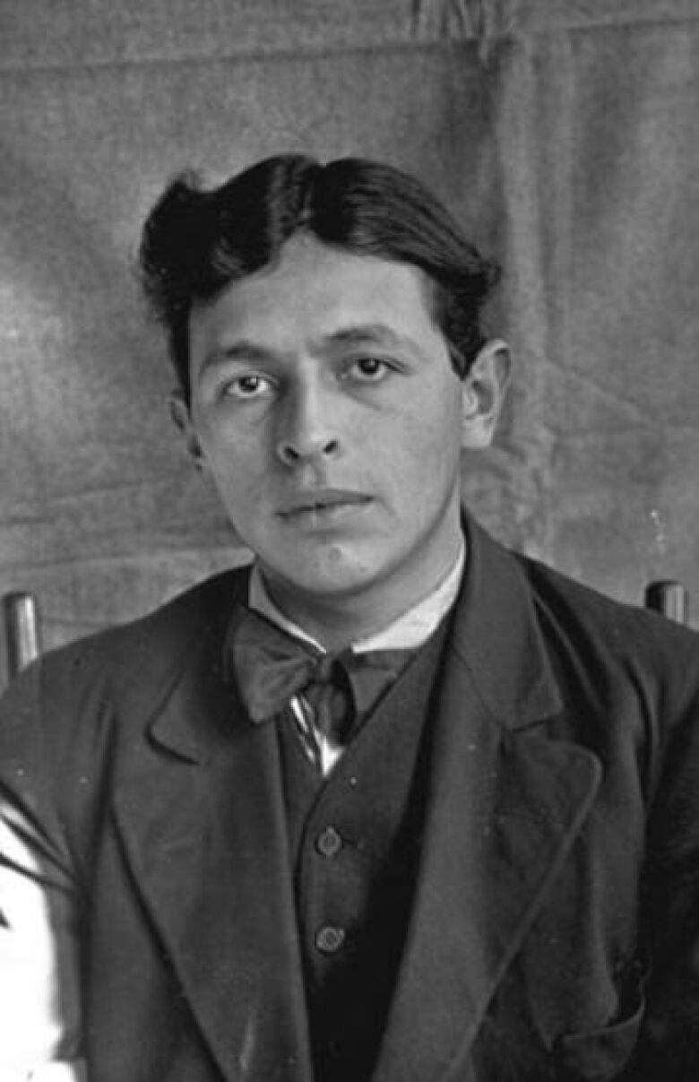 A black and white closeup photo of a young Indigenous man is shown.