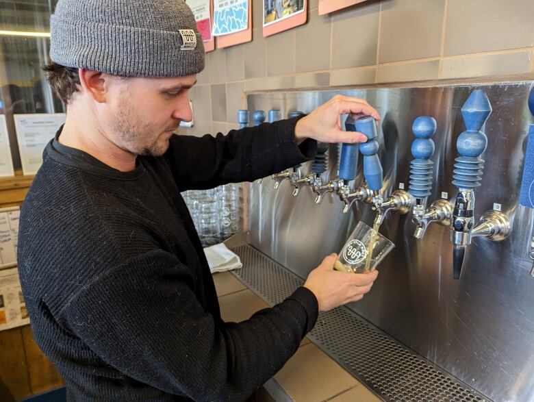 A man pours a beer from a tap