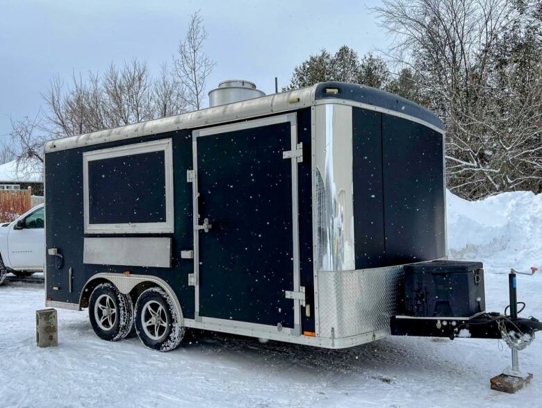 A towable trailer in a snowy parking lot.