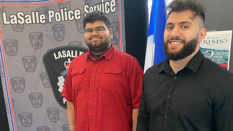 Two students stand in front of a lasalle banner