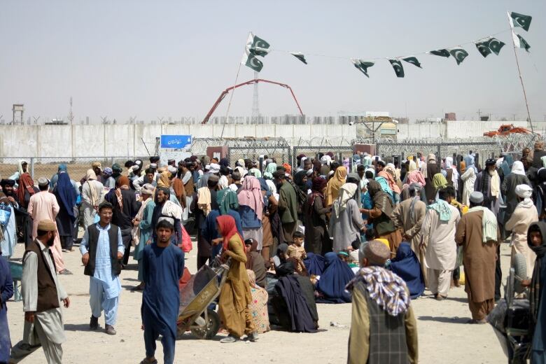 People gather to cross into Afghanistan at the Friendship Gate crossing point at the Pakistan-Afghanistan border town of Chaman, Pakistan September 2, 2021. REUTERS/Saeed Ali Achakzai REFILE - QUALITY REPEAT