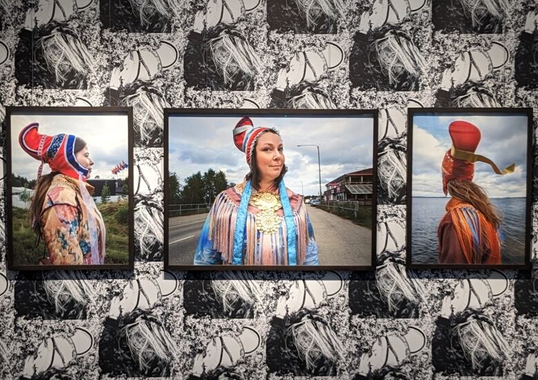 An art installation shows three women in traditional dress.