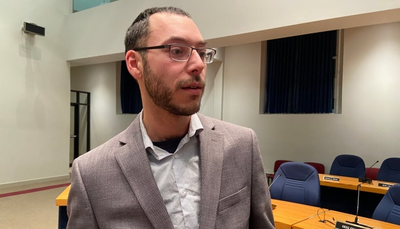 A man speaks to people in the council chambers at the City of Fredericton.