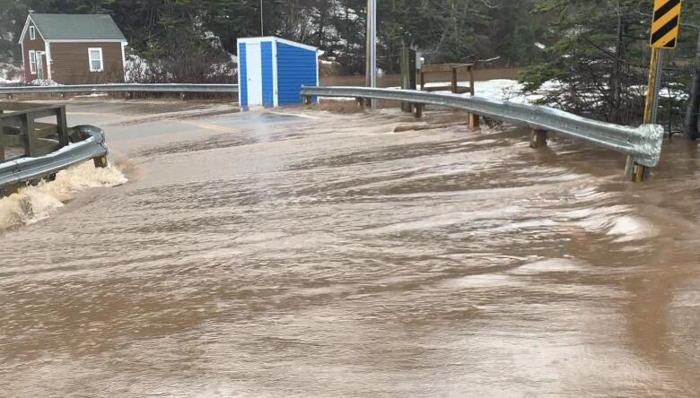 A road is flooded with rushing water.