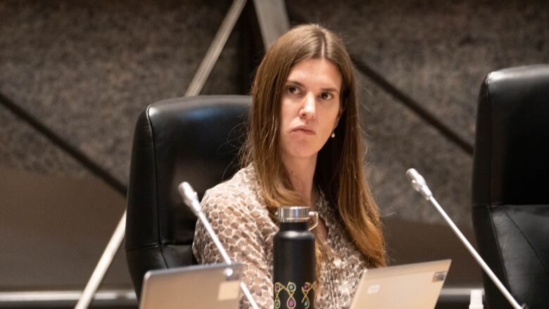 A city councillor listens at her desk during a meeting.