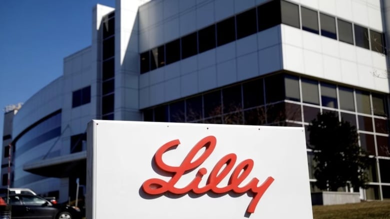 White office building with glass windows, and a white sign with word Lilly in red cursive letters