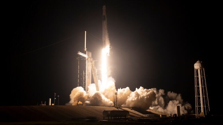 A wide-angle look at the launch of a space rocket from its platform is shown.