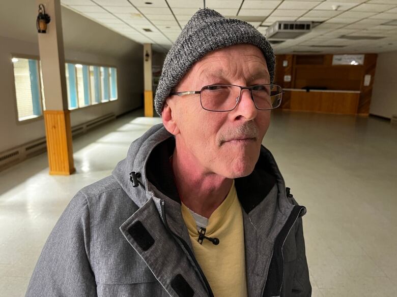 An older man with glasses wearing a toque.