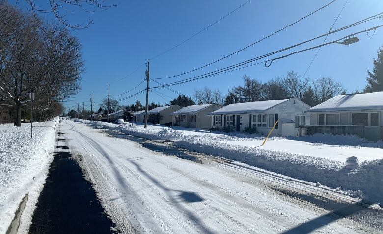 A snowy street lined with houses.