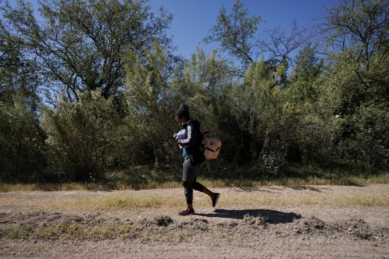 A Cuban national walks along a road after crossing the Mexico-Texas border at the Rio Grande, Sept. 23, 2021, in Del Rio, Texas. The Nicaraguan government announced Monday, Nov. 22, 2021, that it has dropped visa requirements for Cuban citizens, a move that may spark an increase in Cubans travelling there in a bid to reach the United States.