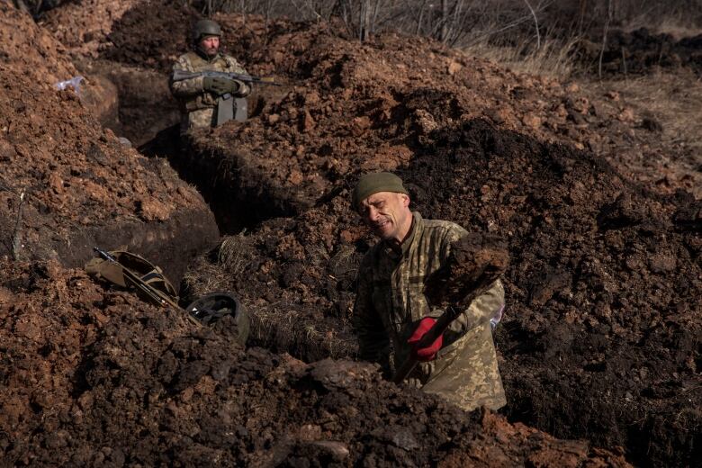 A Ukrainian soldier digs a trench along a frontline stretch outside of Bakhmut, Ukraine.