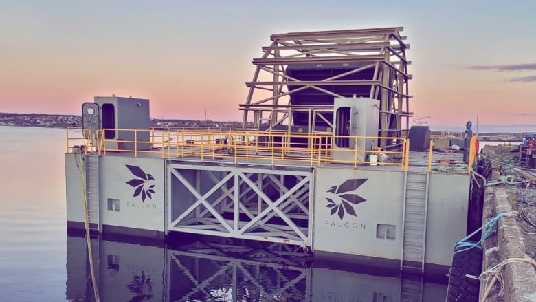 A building is next to a wharf in the water.