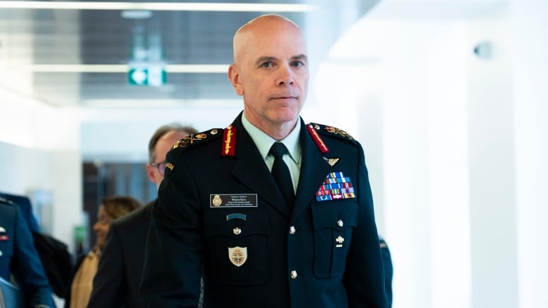 A military official walks down a hall.