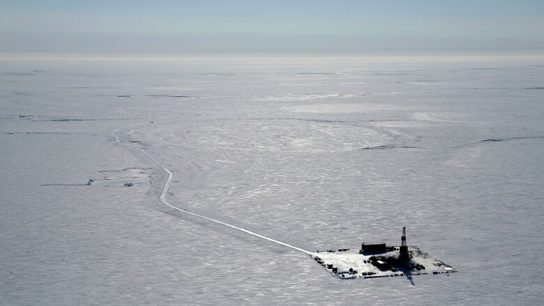 Small oil platform amid vast sea of ice and snow. 