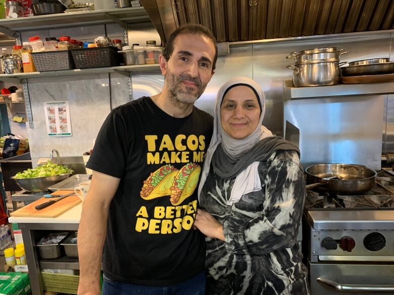 A couple holding each other in a kitchen.