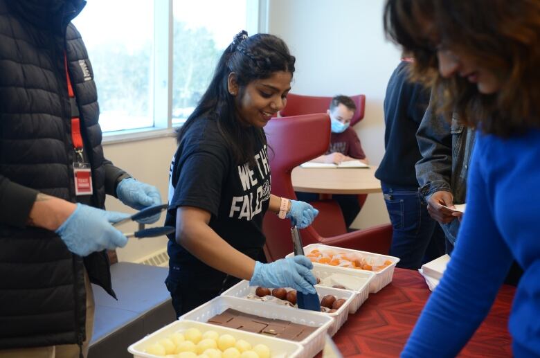 woman wearing black shirts serves desserts