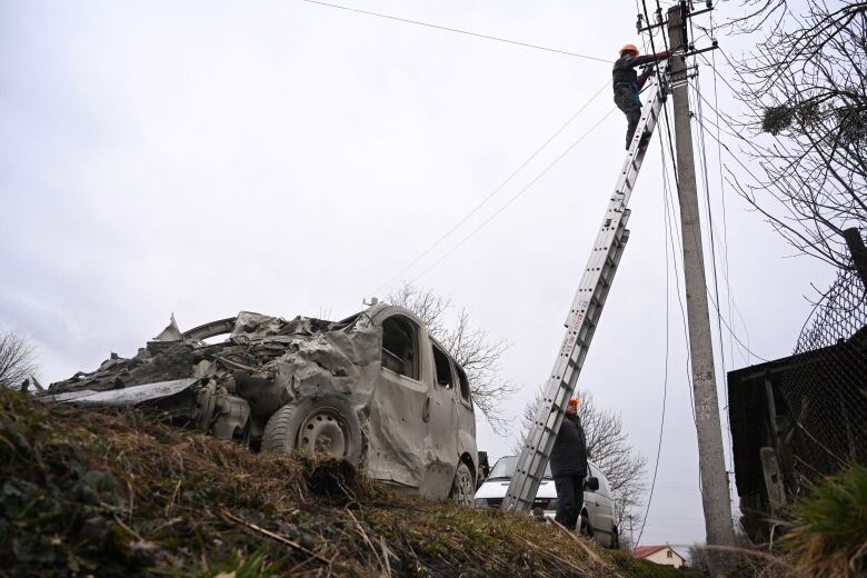 A hydro worker is shown atop a ladder tending to a hydro pole, with a damaged vehicle shown nearby.