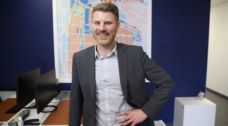 A man in a suit smiles towards the camera.