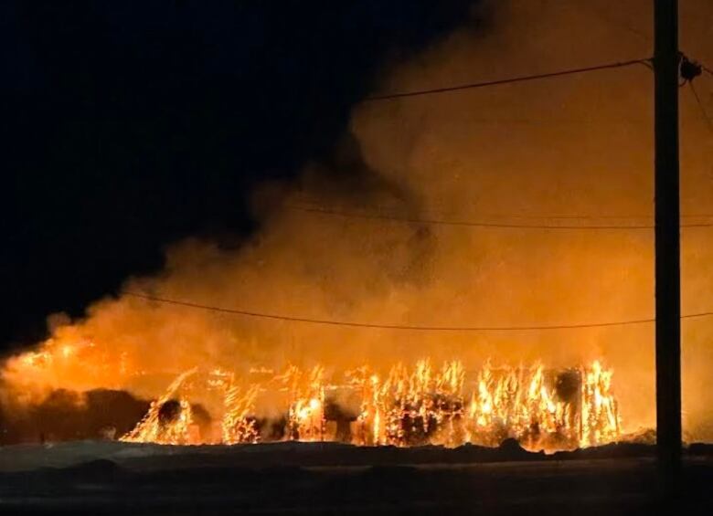 A building is engulfed in flames at night.