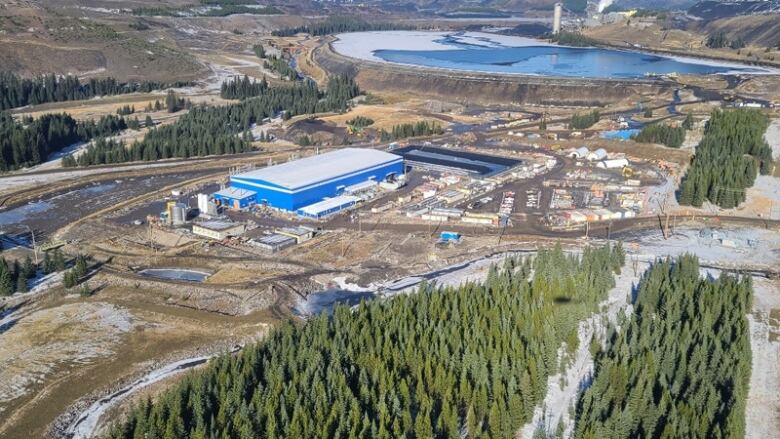 An aerial photograph of a water treatment facility in the foreground and a Teck Resources Ltd. mine in the background.