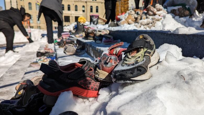 children's shoes sit on snow covered concrete steps