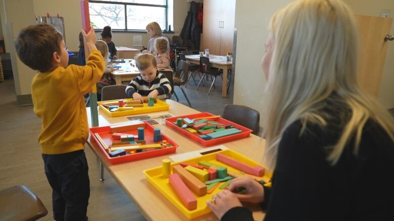 Children play with coloured blocks in a child-care centre. 