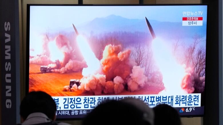 A TV screen shows an image of missile launches.