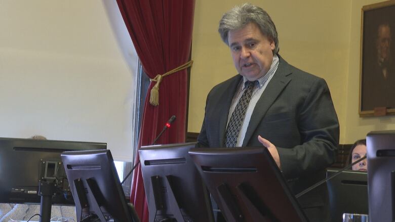 Mitchell Tweel at podium in council chamber.