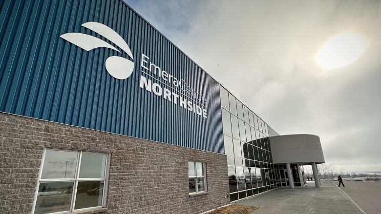 The front of a building is shown with a blue facade and windows and a white logo saying Emera Centre Northside.