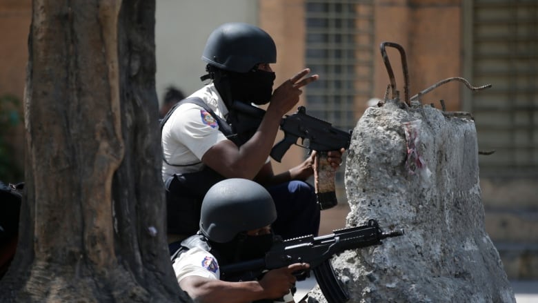 Police officers take cover during an anti-gang operation in the Lalue neighborhood of Port-au-Prince, Haiti on March 3, 2023.