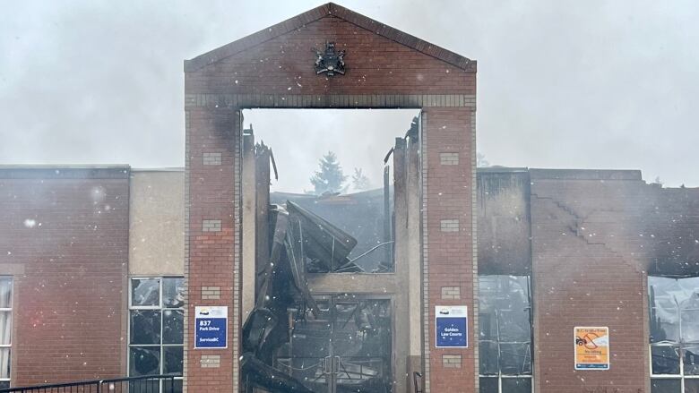 A burned building with smoke coming out of it.