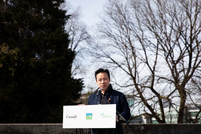 Vancouver Mayor Ken Sim is pictured at a podium.