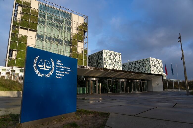 A glass building and blue sign are displayed. 