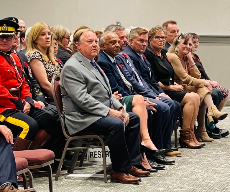 People sit in rows on chairs.