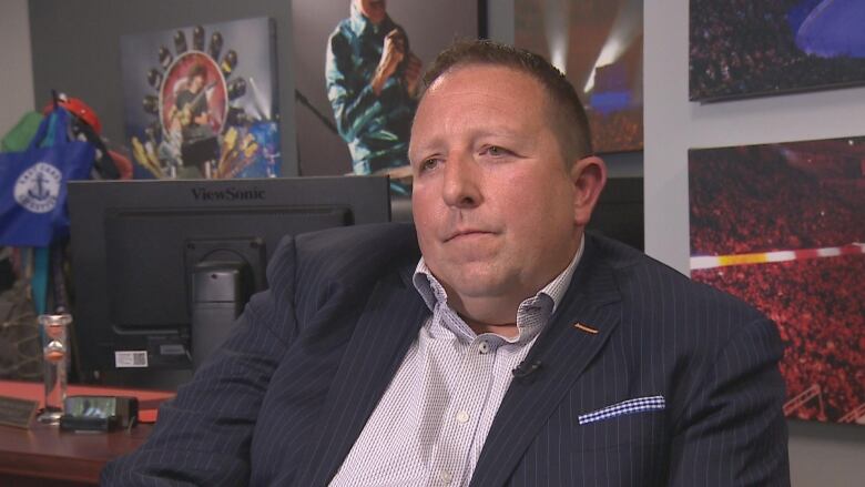 A man in a suit sits in an office.