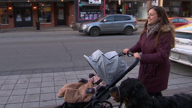 Woman pushing stroller while walking dog