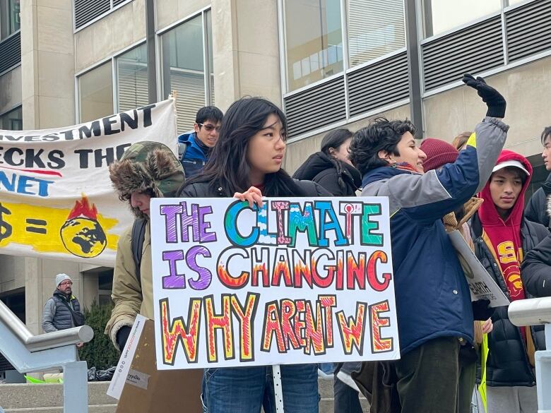 A student protester holds a sign at a climate rally at the University of Toronto on March 3. 2023.