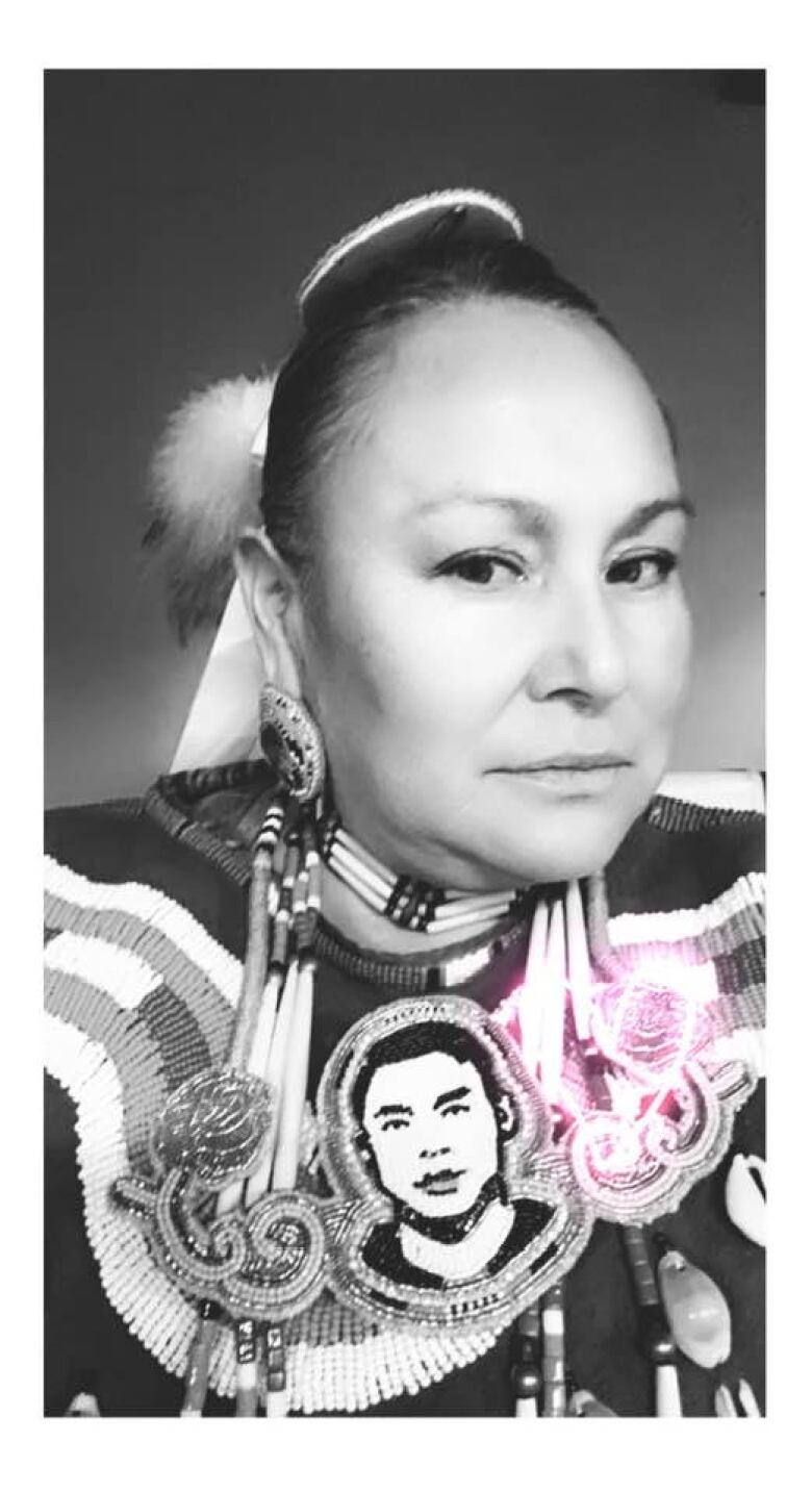 A black and white image of a woman wearing traditional jewelry.