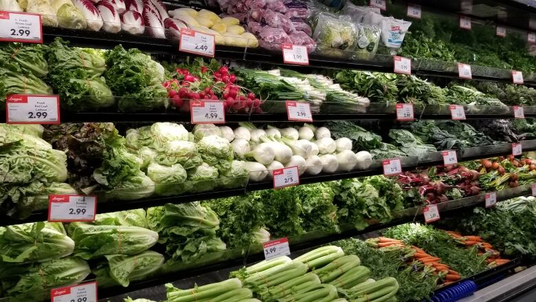 Vegetables are shown in the produce section of a grocery store.