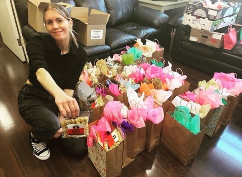 A woman next to colourful bags.