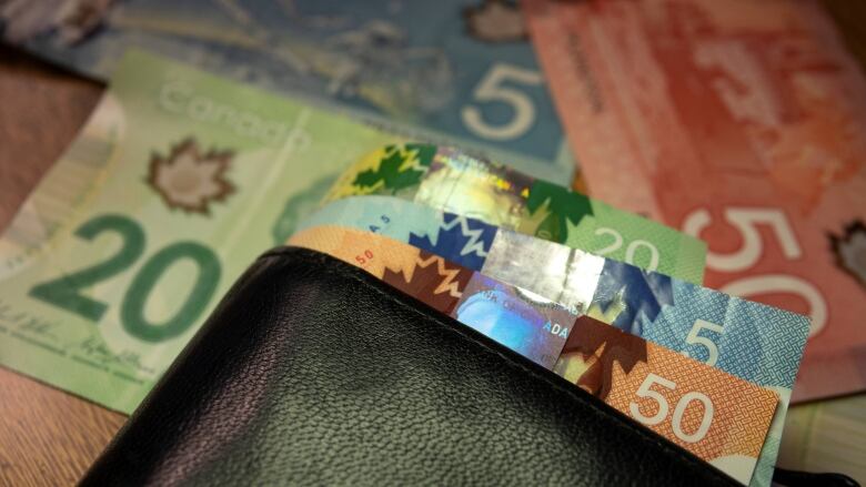 Colourful Canadian bills peeking out of a wallet.