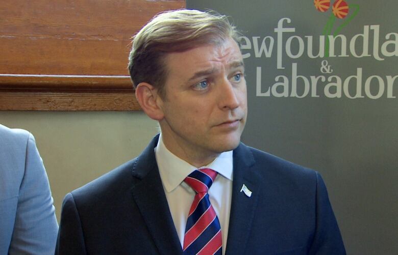 A man wearing a blue suit and a red and blue striped tie.