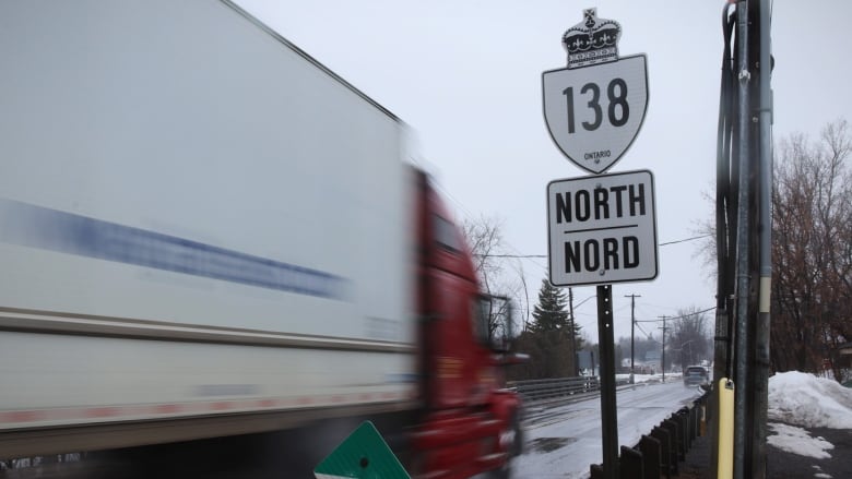 A transport truck drives along a highway in winter.