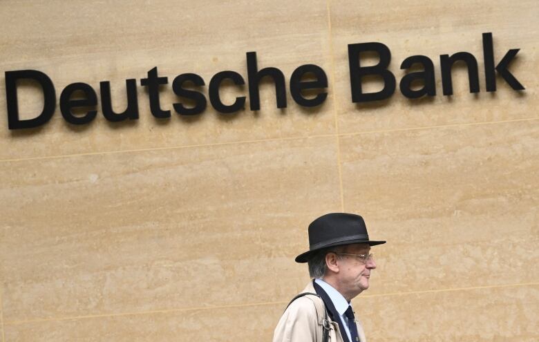 A worker walks past Deutsche Bank offices in London,, March 16, 2023. REUTERS/Toby Melville