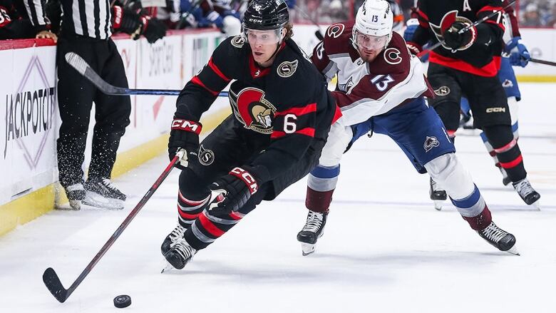 Men's hockey player takes control of the puck during an NHL game.