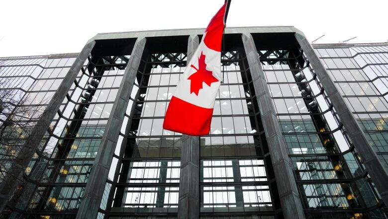 A Canadian flag hangs from a building.